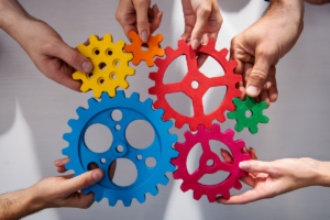 hands holding colorful cogs together